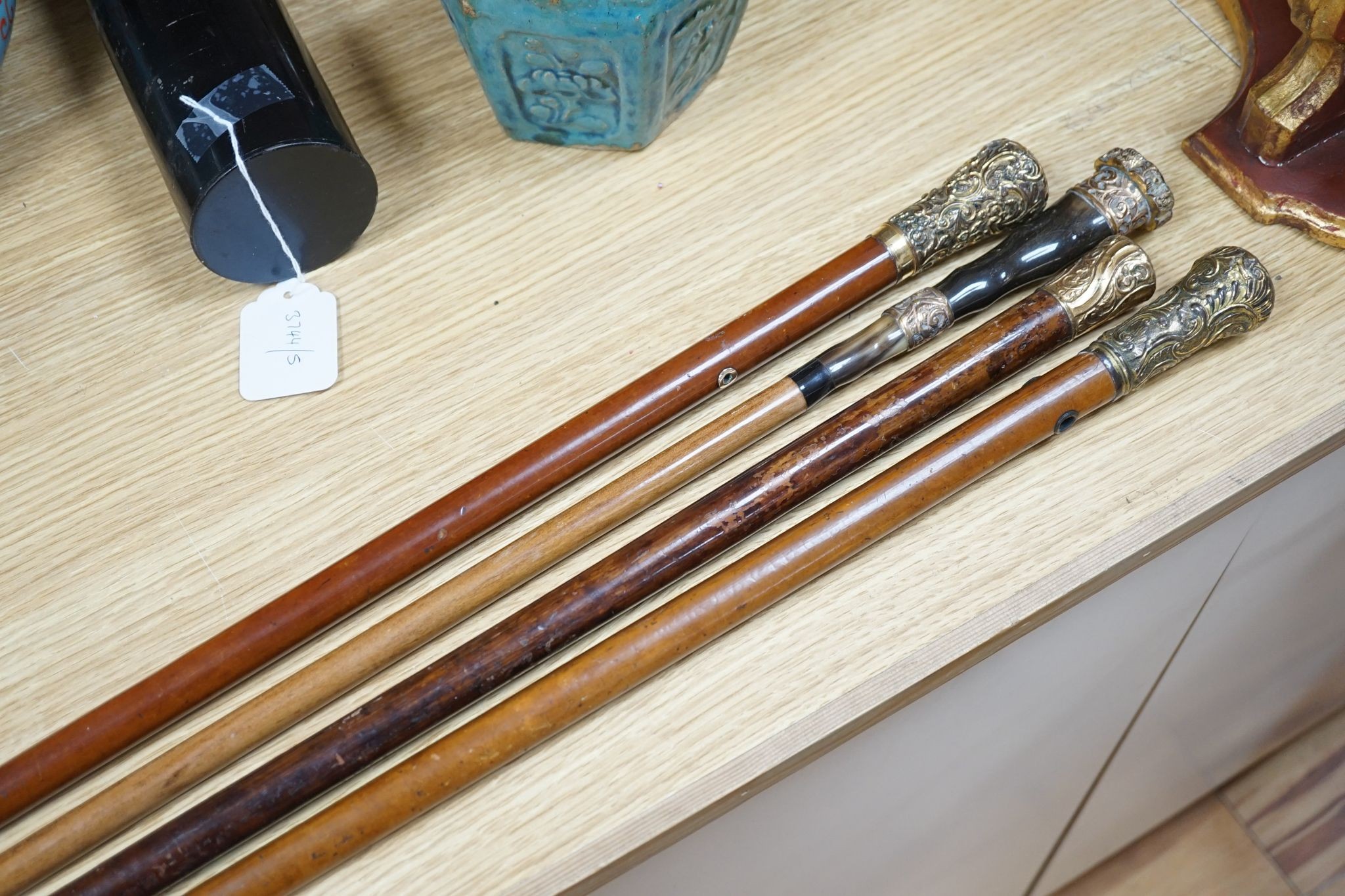 Four Victorian gilt-metal mounted walking canes, longest 97cm